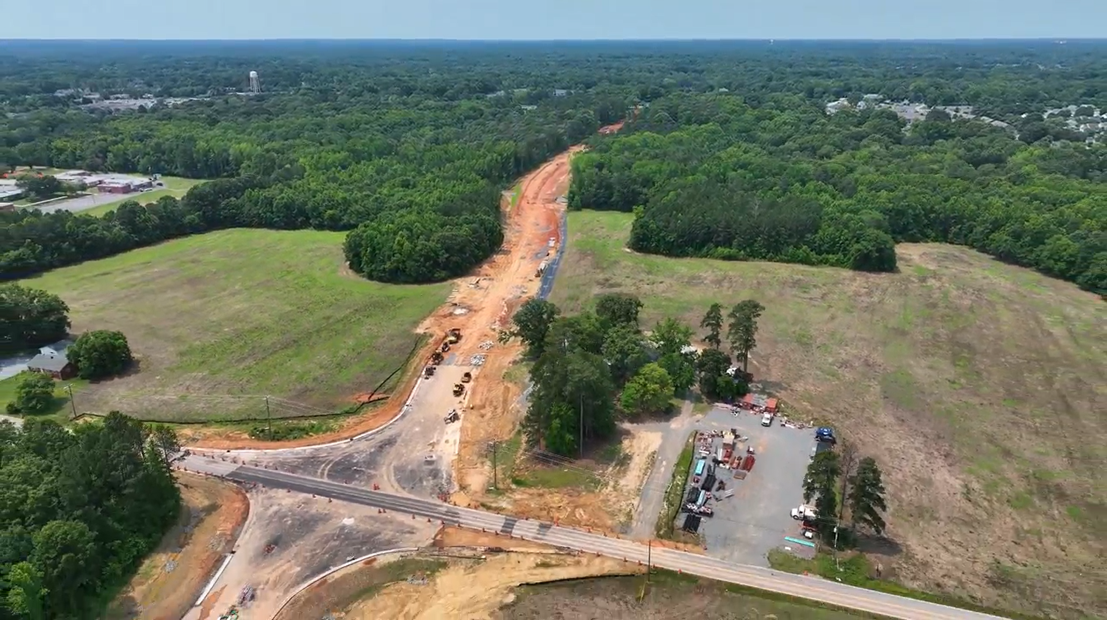 A new road under construction. Equipment is moving dirt to create the base for the road.
